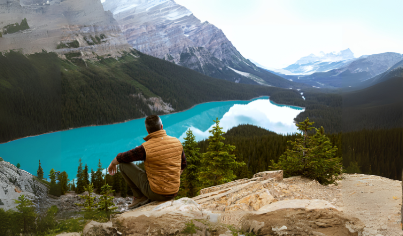 a man seatinh on the top of the mountain image